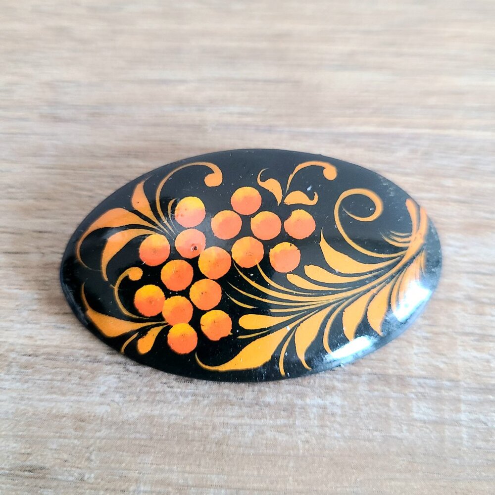 Hand painted wooden lacquered brooch with berries and leaves.